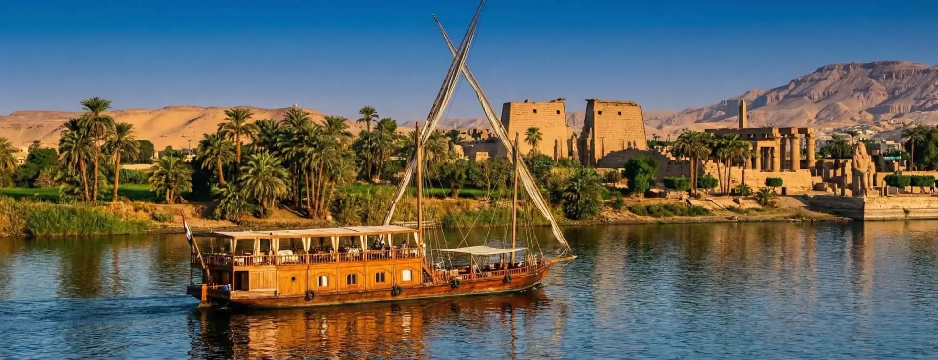 Een houten dahabeya op de Nijl voor de Luxortempel